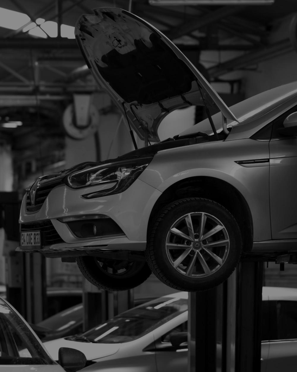 Silver hatchback with its bonnet open in a workshop