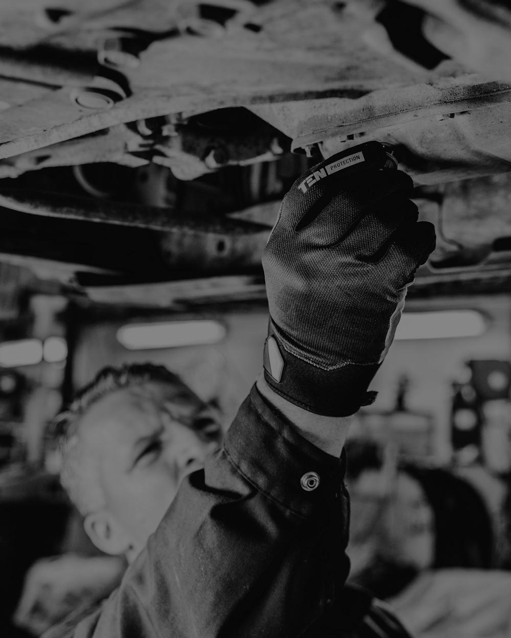 Mechanic inspecting the underside of a car